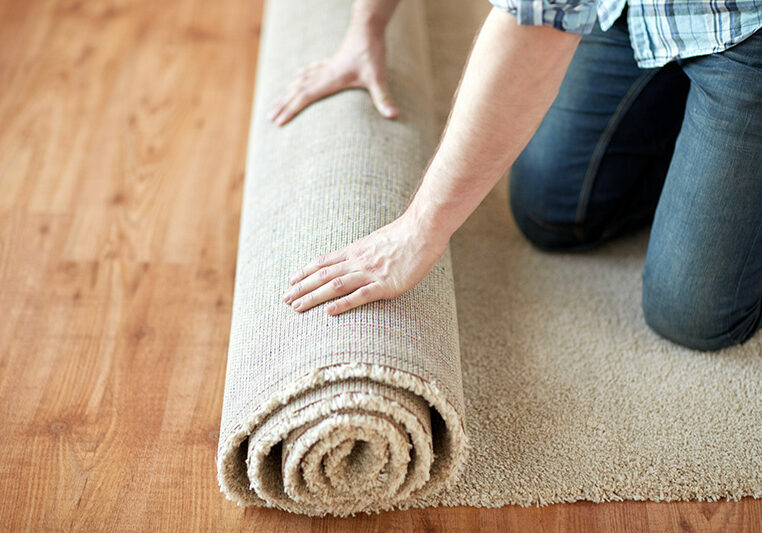 close up of male hands rolling carpet | Jimmie Lyles Flooring Gallery