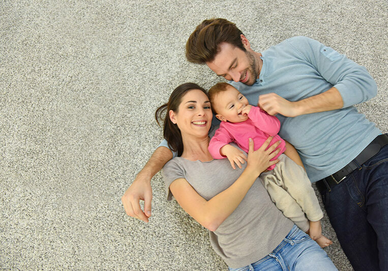 Upper view of family of three laying on carpet | Jimmie Lyles Flooring Gallery
